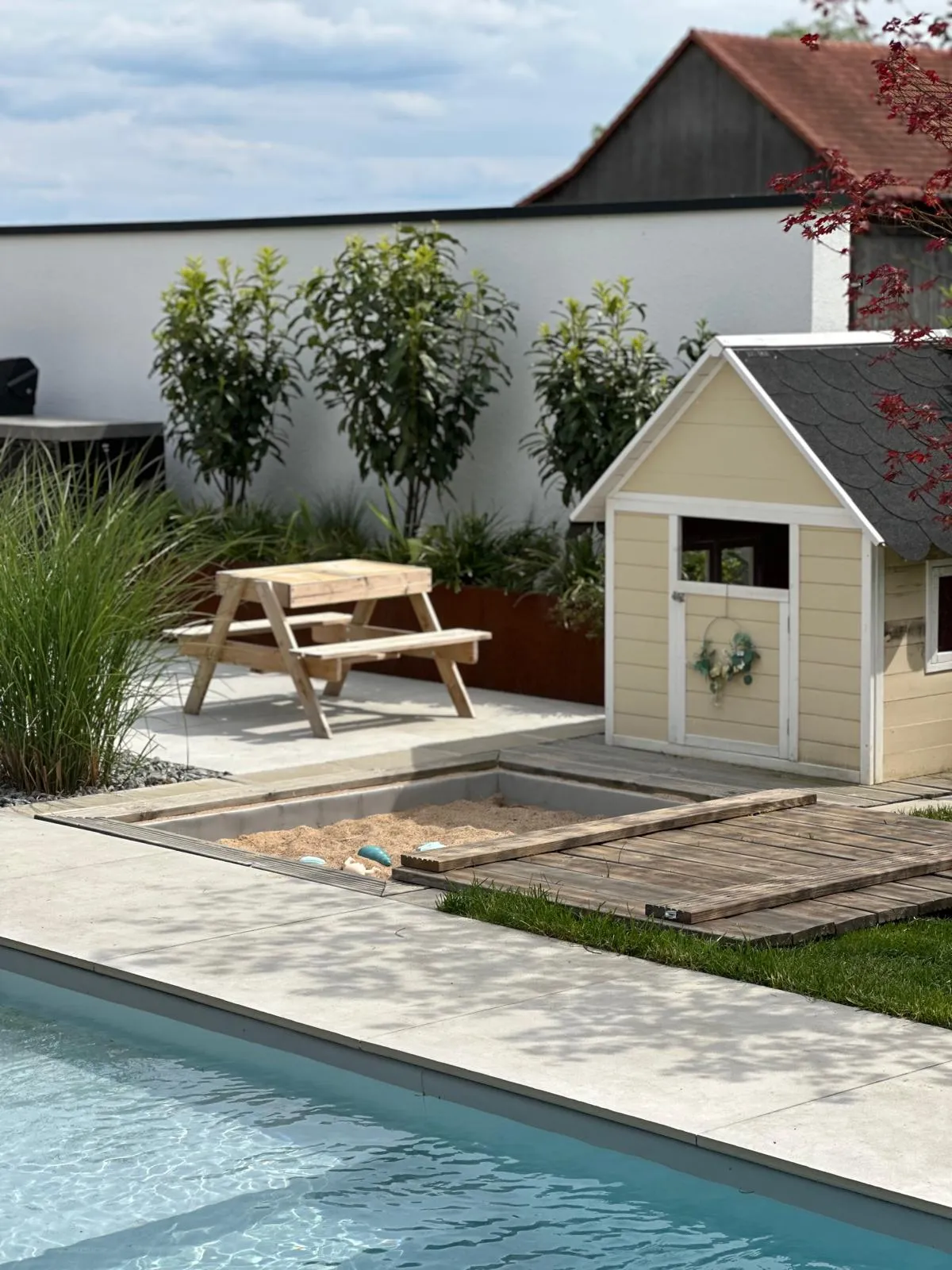 Individuell gebauter Holz-Sandkasten im Garten